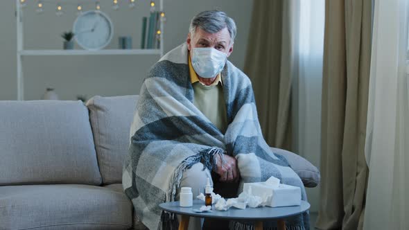 Upset Sick Grandpa in Medical Mask Sitting on Couch Caucasian Elderly Man Wrapped in Blanket Feel