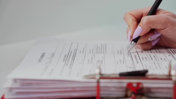 Close up of female hand filling form. Womans hand with pen completing personal information on form