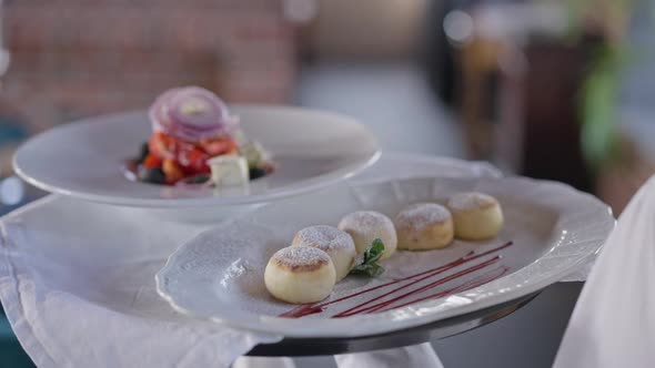 Closeup White Plates with Dessert and Salad on Tray in Male Caucasian Hand