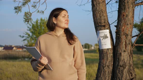 Worried Woman Holds Paper Stack Near Missing Cat Poster