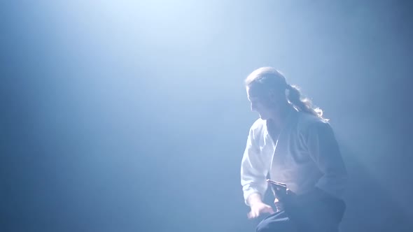 Fight Between Two Aikido Fighters in Dark Studio with Smoke and Lighting. Slow Motion. Close Up.