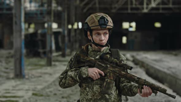 Trained Female Soldier with Gun Walking on Destroyed Plant