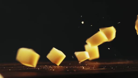 Pieces of Hard Cheese with Crumbles Fall Down Onto Table