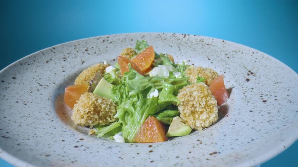 Salad with Grapefruit Green Lettuce Avocado Tuna and Cheese on a Gray Plate Rotating Close Up on a