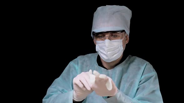Surgeon Puts on Protective Gloves and Prepares for the Operation. Preparing To Work As a Surgeon
