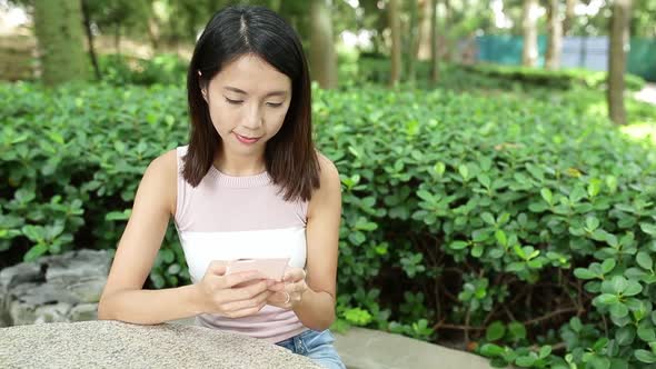 Woman use mobile phone in park