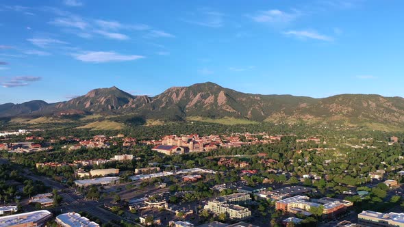 Morning drone footage flying over Boulder, Colorado. Flies over buildings with a focus on the mounta