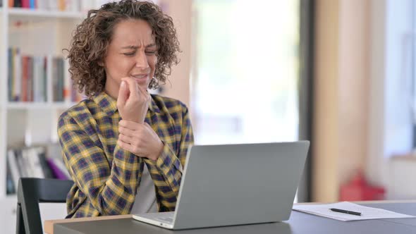 Mixed Race Woman with Wrist Pain Using Laptop at Work 