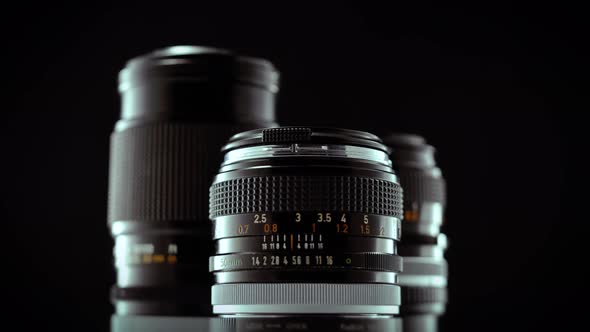 Vintage 50mm Camera Lens Spinning On Black Studio Background