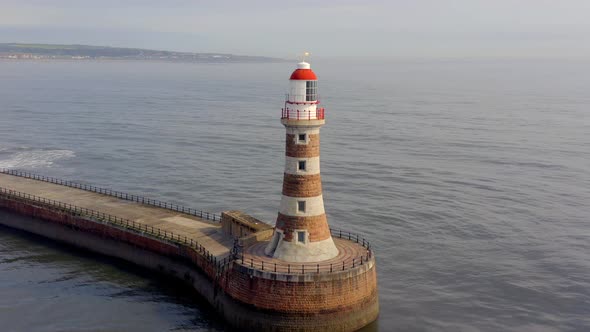 A Lighthouse and Pier in the Early Morning