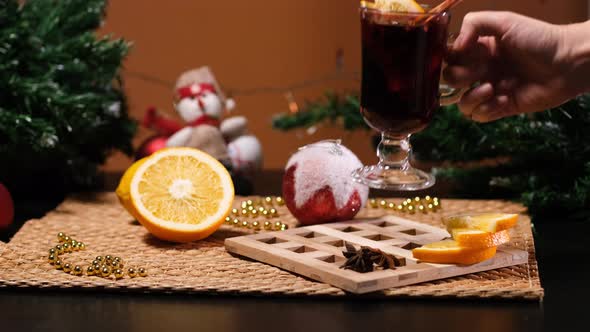 Hand of Woman Putting Mulled Wine on a Table