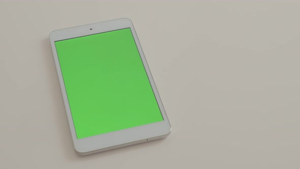 Tablet-pc  with green screen display on white reflective background 4K 2160p UltraHD footage - Green