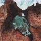 Wave streams into caves on wild coast shot by drone - VideoHive Item for Sale