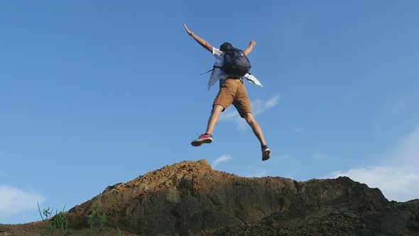 Backpacker Jumping At The Top