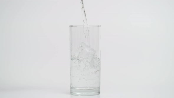 Slow Motion of Pouring Water in Glass with Ice at 1000 Fps White Background