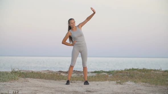 Girl Exercises Near the Sea