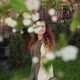 Beautiful Young Woman Stands Under a Blooming Apple Tree in a Spring Garden - VideoHive Item for Sale