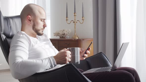 Bearded businessman working at home sitting in armchair. Business and investments concepts.