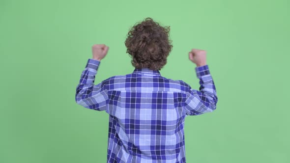 Rear View of Happy Young Hipster Man with Fists Raised