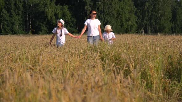 Mother with Daughter and Son Walking in a Field