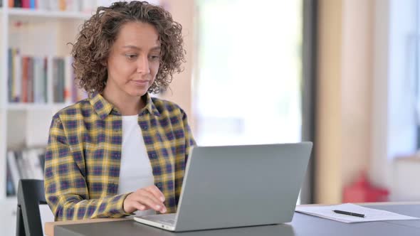 Young Mixed Race Woman Reacting to Loss on Laptop at Work