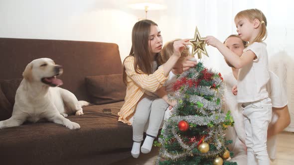 Portrait of Dog and Happy Family in the Background with Christmas Tree