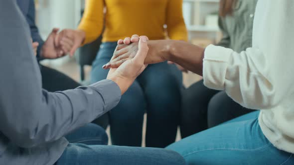 A Group of People Join Hands in a Circle During a Group Therapy Session