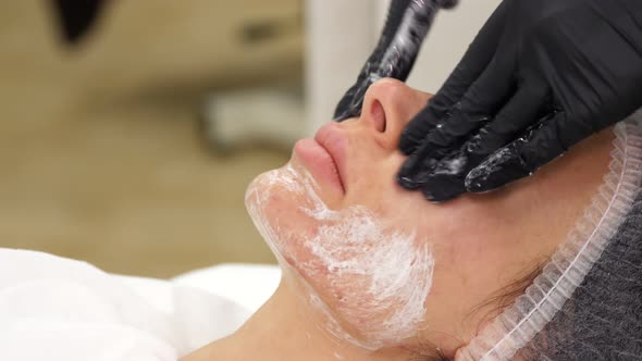 Close-up, Beautician in Black Medical Gloves Performs Cosmetic Skincare Procedure, Applies Cleansing