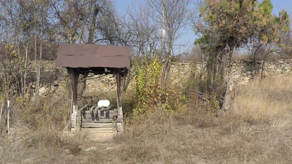 Flying nearby old weathered water well 4K drone footage