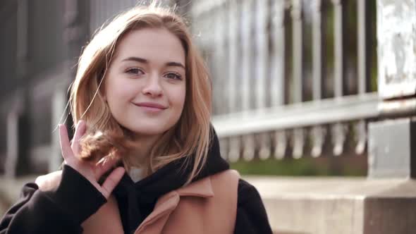 Portrait of Smiling Young Woman Having Leisure Standing Against Beautiful Building Touching Her