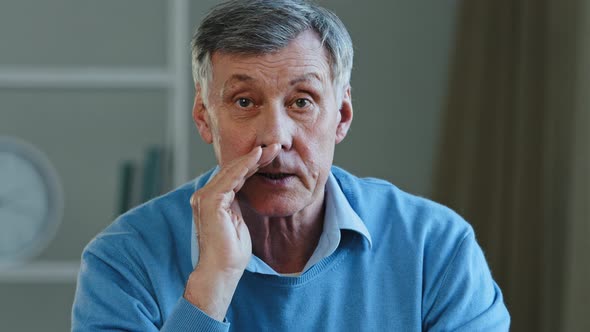 Closeup Old Man Telling Secret Looking at Camera Quietly Closing Mouth with Hand Elderly Mature
