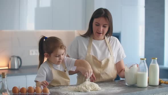 The Girl and Her Mother Cook Together in the Kitchen and Mold the Dough with Their Hands