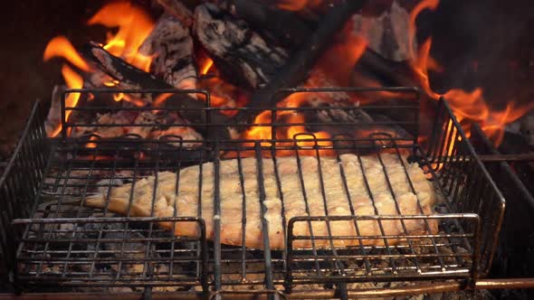 Mackerel Fish Flipped on the Barbeque Grid on the Background the Burning Fire