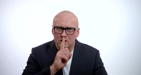 A Close-up Portrait of a Serious, Stern Man with Glasses, Wearing a Black Jacket and White Shirt, He