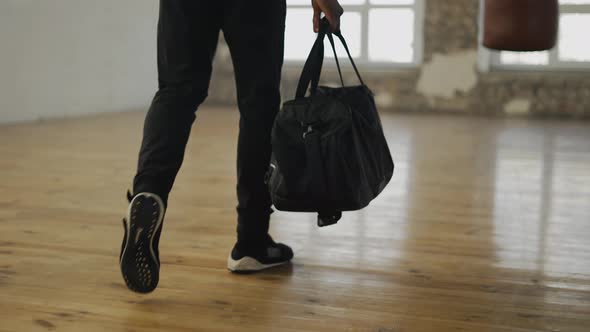 Cropped View of an Athlete Walking Into Room with a Bag Ready to Start Training