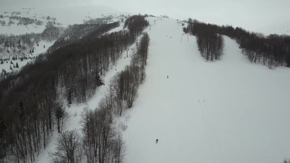 Carpathian Ski Resort From a Height. Flight Over Mountains. Bird's Eye View of People Descending