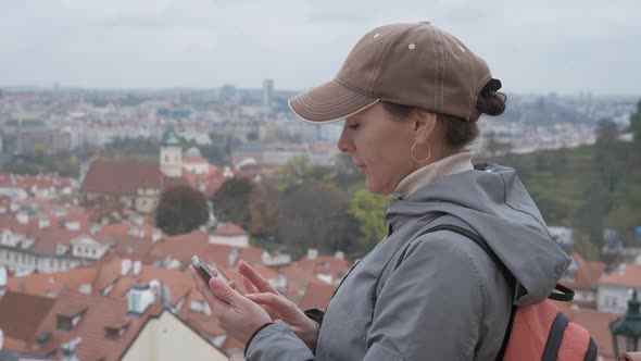 Girl tourist is looking at a map in a smartphone.