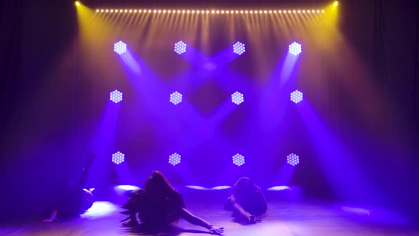 Three Sexy Womans in Erotic Leather Costume Dances. Silhouettes on Background Smoke and Neon