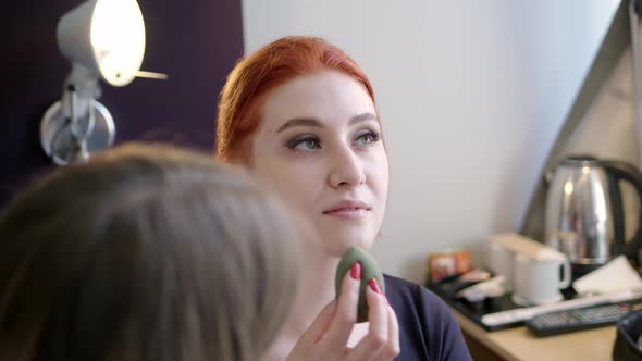 Attractive Redhaired Woman is Doing Makeup