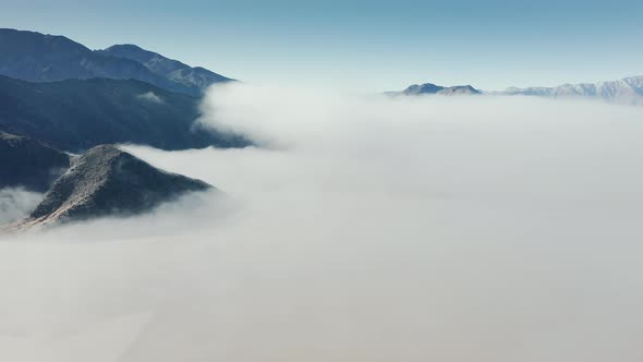 Beautiful Aerial Flying Above Death Valley Desert Covered By White Fog Clouds