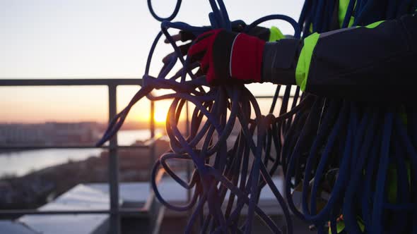 Industrial Climber Tries to Untangle Blue Safety Rope