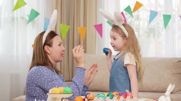 Mother and Sweet Daughter Play with Easter Eggs in Game of Who Will Break