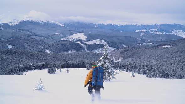 A Tourist Walks Through the Snow in the Mountains.