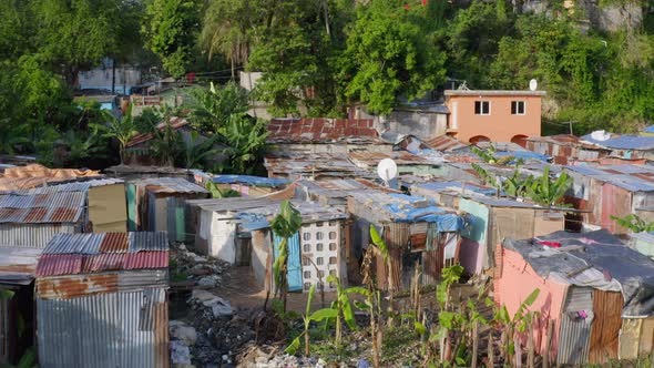 Aerial backward over dilapidated shacks near Ozama river, Santo Domingo