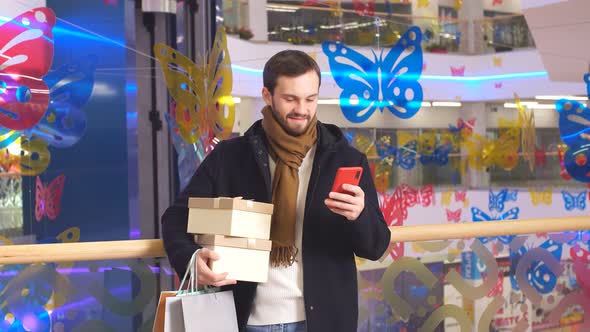 Young Shopaholic Came To Mall for Shopping, Uses Smartphone To Search for Discounts