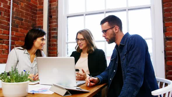 Group of executives discussing over laptop in the conference room