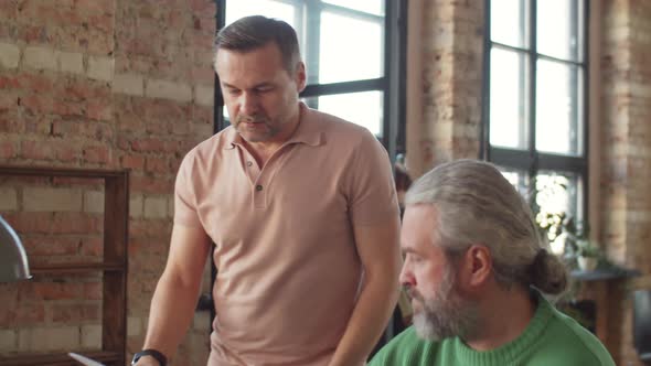 Mature Businessmen Cooperating during Workday in Office