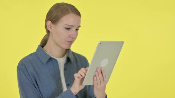 Young Woman Using Digital Tablet on Yellow Background