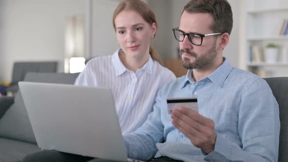 Happy Young Couple Making Successful Online Payment on Laptop