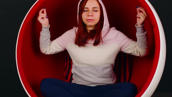 Young Woman Meditating in Ball Chair